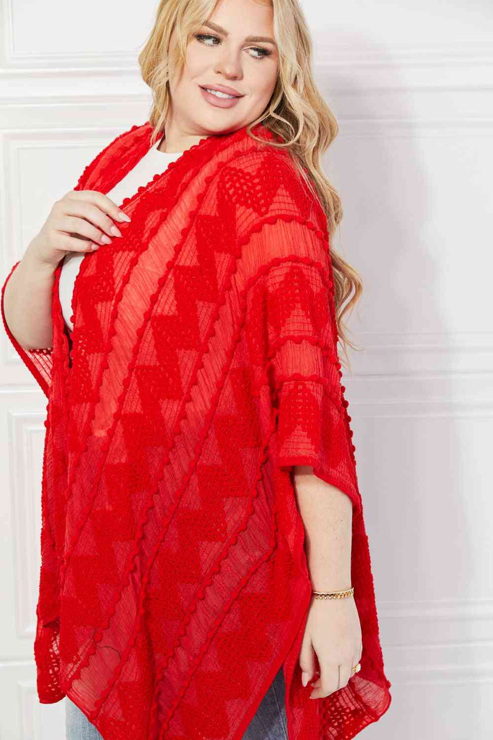 Cárdigan tipo poncho asimétrico con pompones en rojo de Justin Taylor