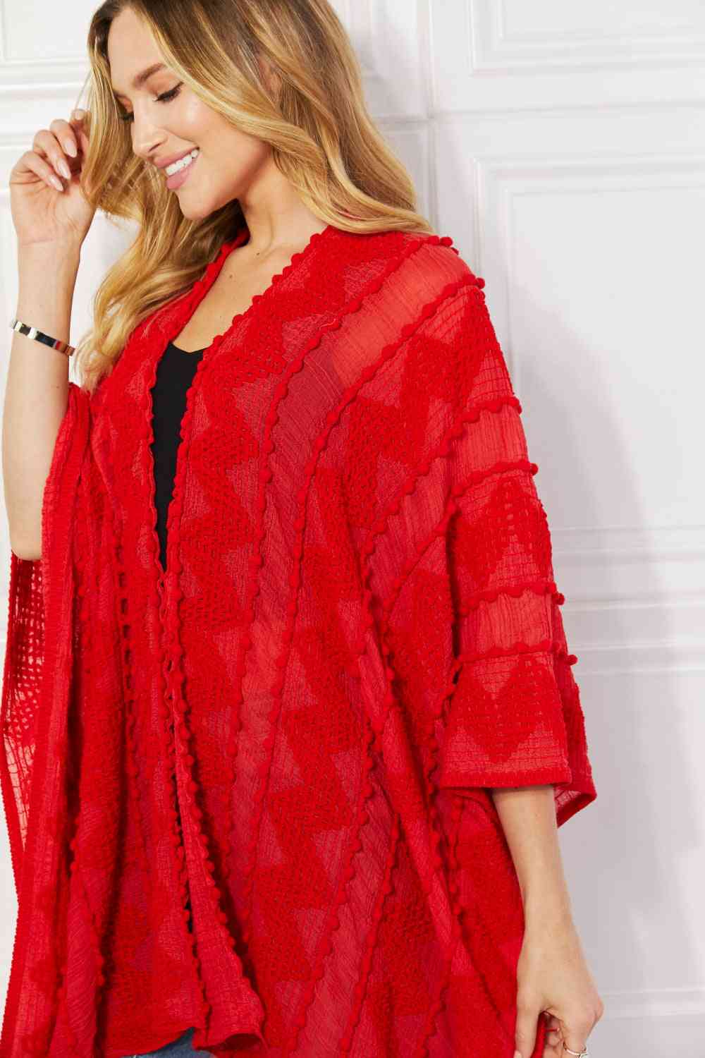 Cárdigan tipo poncho asimétrico con pompones en rojo de Justin Taylor