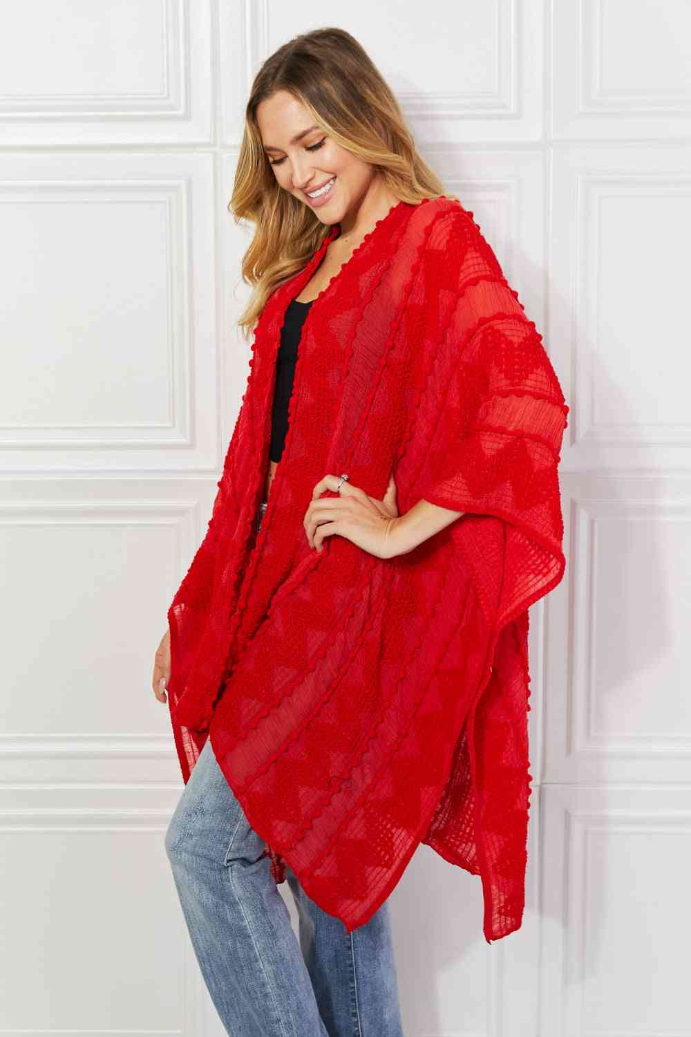 Cárdigan tipo poncho asimétrico con pompones en rojo de Justin Taylor