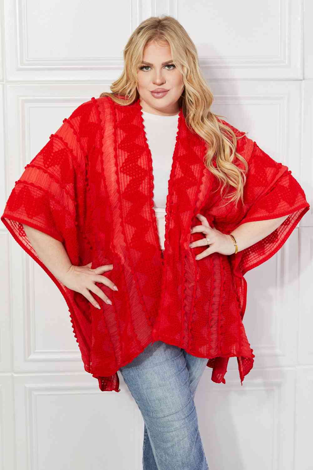 Cárdigan tipo poncho asimétrico con pompones en rojo de Justin Taylor