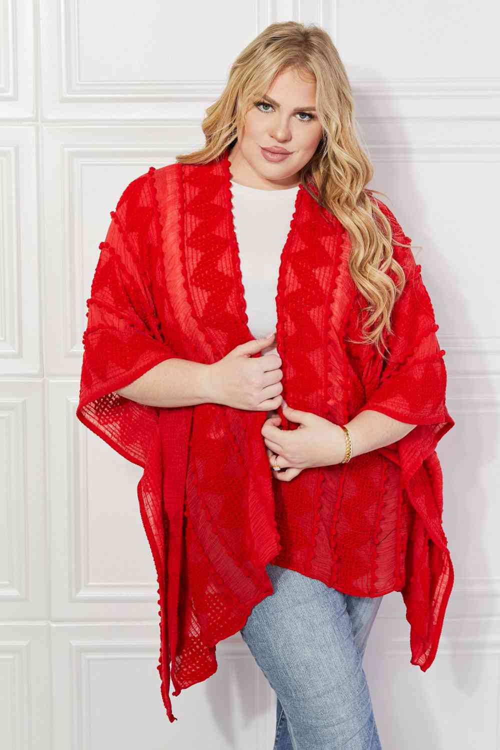 Cárdigan tipo poncho asimétrico con pompones en rojo de Justin Taylor