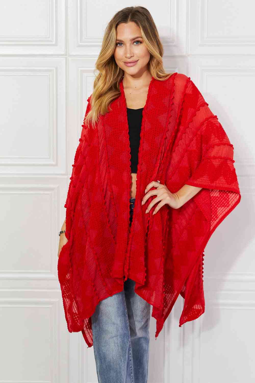 Cárdigan tipo poncho asimétrico con pompones en rojo de Justin Taylor