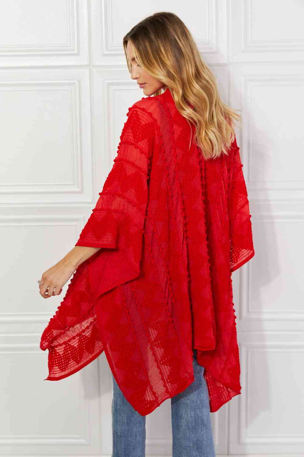 Cárdigan tipo poncho asimétrico con pompones en rojo de Justin Taylor